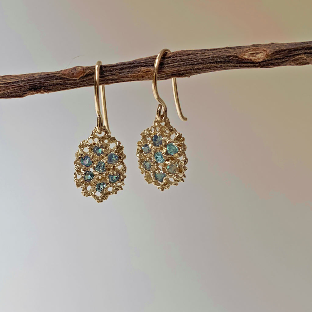 Textured, lacy, lemon-shaped earring, shown in yellow gold with a soft watery palette of alexandrite greens