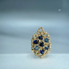 Textured, lacy, lemon-shaped pendant or earring, shown in 14k yellow with a mix of blue stones