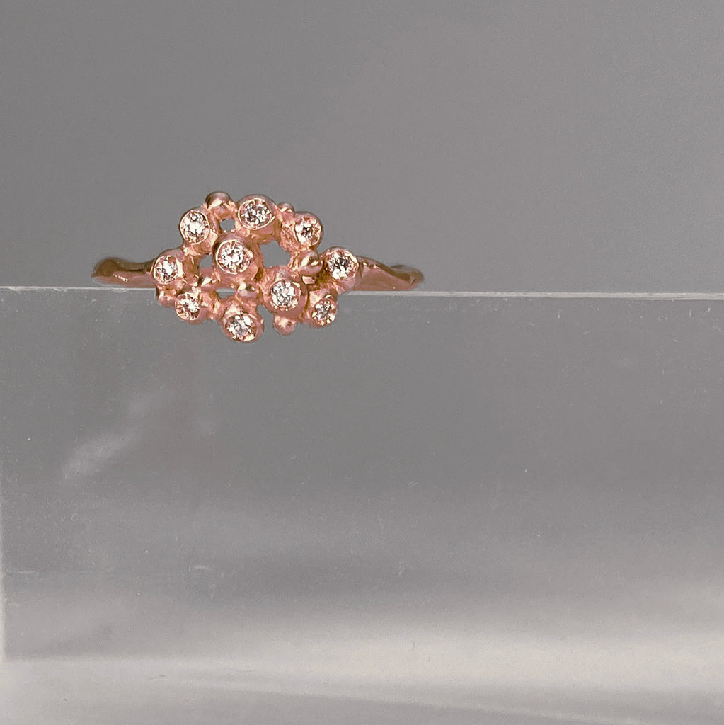 Ring with cluster of 10 tiny diamond "buds"; shown in rose gold with a satin finish