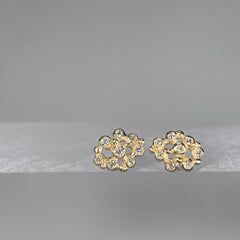 A stud made up of 8 larger, roundish balls ("buds") that each hold a diamond, and 6 tiny balls for accents; the overall feel is lacy because of the space between the various components; shown in 14k yellow