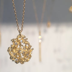 Substantial, textured, pear-shaped pendant shown in rich yellow 14k with diamonds of varying sizes