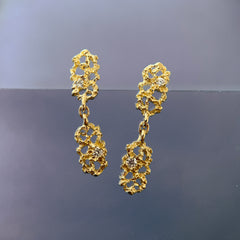 textured earrings with negative space made up of two similar components: there are two imperfect  rectangles that hang end to end, each with a small white diamond; shown in 14k yellow